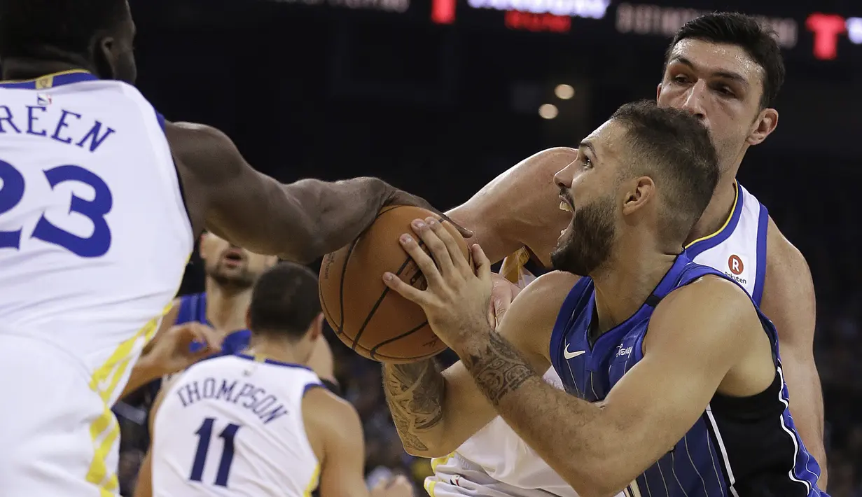 Pemain Orlando Magic, Evan Fournier (tengah) berusaha melewati kepungan pmain Warriors pada lanjutan NBA Basketball game di Oracle Arena, Oakland, (13/11/2017). Warriors menang 110-100. (AP/Ben Margot)