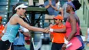 Petenis putri AS, Venus Williams dan juara bertahan Johanna Konta berjabat tangan seusai babak 16 besar Miami Terbuka di Candon Park, Senin (26/3). Venus sukses melaju ke perempat final setelah mengalahkan Johanna Konta. (AP Photo/Joe Skipper)