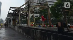 Sejumlah petugas membersihkan puing Halte Transjakarta Tosari imbas unjuk rasa menolak Omnibus Law UU Cipta Kerja di Jalan M.H. Thamrin, Jakarta, Sabtu (10/10/2020). Wagub DKI Jakarta Ahmad Riza Patria memperkirakan kerugian imbas ujuk rasa tersebut mencapai Rp.65 miliar. (merdeka.com/Imam Buhori)