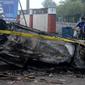 Mobil dibakar di luar Stadion Kanjuruhan, Malang, Jawa Timur, Minggu (2/10/2022). Sebanyak 127 orang tewas ketika para penggemar yang marah menyerbu lapangan sepak bola setelah pertandingan antara Arema FC dan Persebaya Surabaya pada 1 Oktober 2022. (PUTRI/AFP)