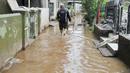 Warga melintasi jalan yang tergenang air di Jalan Arus, Cawang, Jakarta, Senin (7/11). Sebelumnya, ratusan rumah warga di RW 02 Cawang, Kramat Jati, Jakarta Timur tergenang akibat banjir kiriman dari kawasan Bogor. (Liputan6.com/Yoppy Renato)