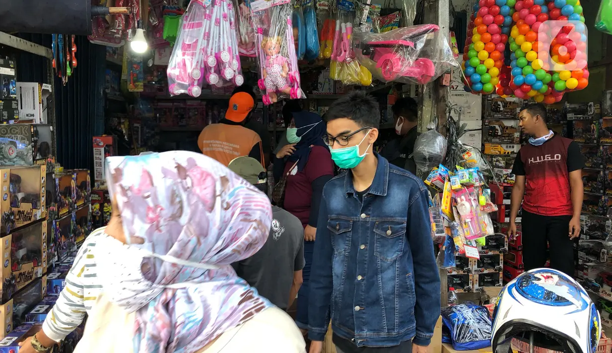 Warga memilih mainan tanpa menjaga jarak di Pasar Gembrong, Jakarta Timur, Minggu (31/5/2020). Meski penerapan masa Pembatasan Sosial Berskala Besar (PSBB) di Jakarta masih berlaku, namun pasar yang khusus menjual pernak-pernik mainan anak ini kembali dipadati warga. (Liputan6.com/Immanuel Antonius)