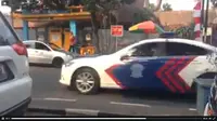 Mobil patroli dan pengawal (patwal) polisi terekam video melawan arah saat mengawal mobil pengantin di Jalan Ir H Djuanda (Dago), Bandung.