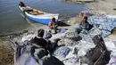 Nelayan menyortir hasil tangkapan mereka di tepi Danau Razzaza, juga dikenal sebagai Danau Milh, di provinsi Karbala, 14 Februari 2022. Salah satu danau terbesar di Irak mengalami penurunan tingkat air yang signifikan dan telah dilanda polusi dan tingkat salinitas yang tinggi. (AP Photo/Hadi Mizban)