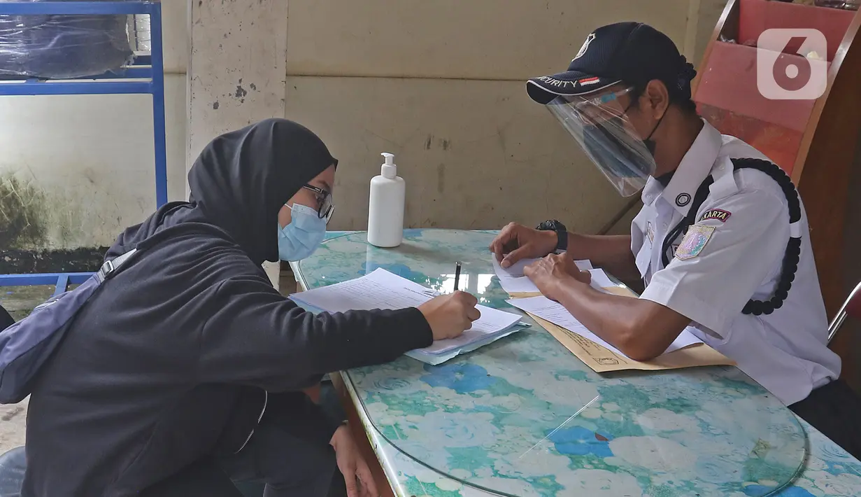 Pasien sembuh COVID-19 mengisi data penjemputan seusai meninggalkan ruangan isolasi Graha Wisata Ragunan di Jakarta, Jumat (29/1/2021). Sebanyak 68 pasien covid-19 dari total 81 pasien yang melakukan isolasi di tempat tersebut telah dinyatakan sembuh. (Liputan6.com/Herman Zakharia)
