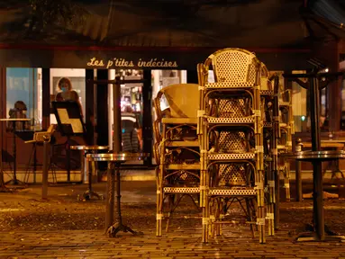 Tumpukan kursi di teras bar yang tutup di Paris di tengah langkah-langkah baru untuk memerangi penyebaran cepat Covid-19 pada Senin (5/10/2020). Seluruh bar dan kafe di Paris – yang diberlakukan siaga maksimum Covid-19 – ditutup selama dua pekan, yang dimulai 6 Oktober. (GEOFFROY VAN DER HASSELT/AFP