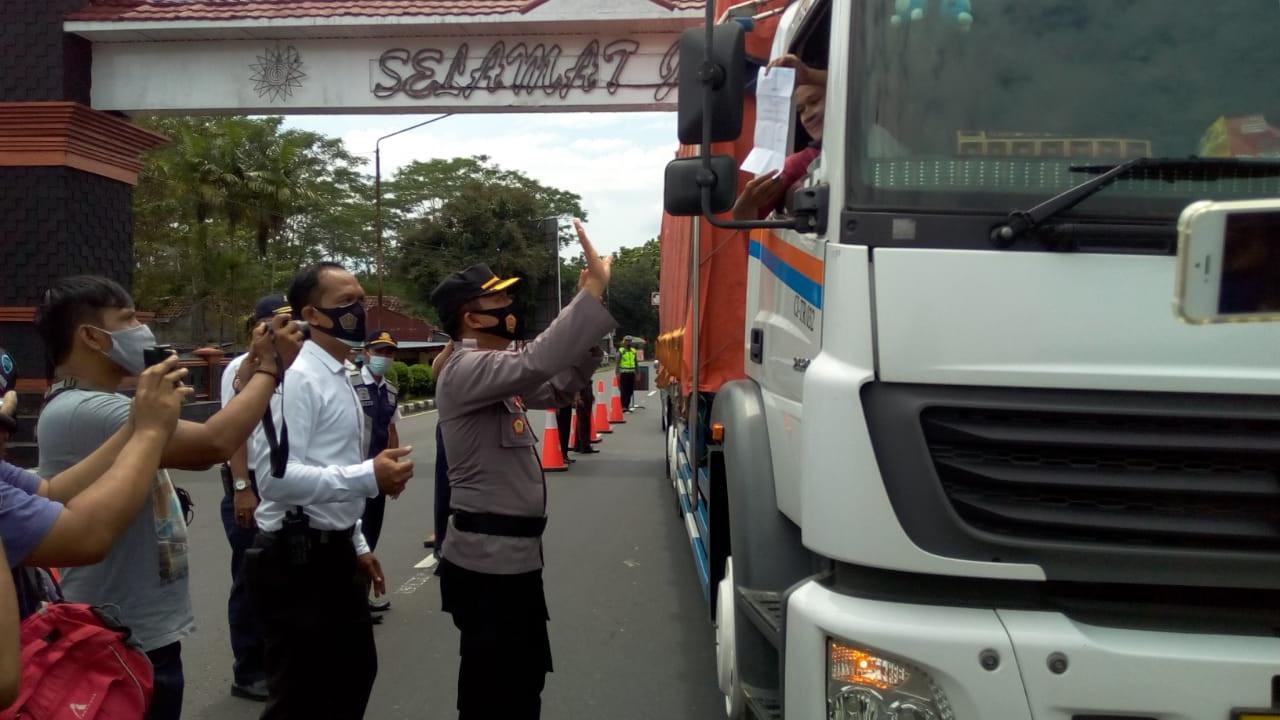 Petugas Kepolisian Resor Purbalingga meminta Sukron, seorang sopir truk, menunjukkan surat keterangan bebas Covid-19 saat operasi yustisi dalam rangka PPKM di perbatasan Banyumas-Purbalingga, Senin (11/1/2021).