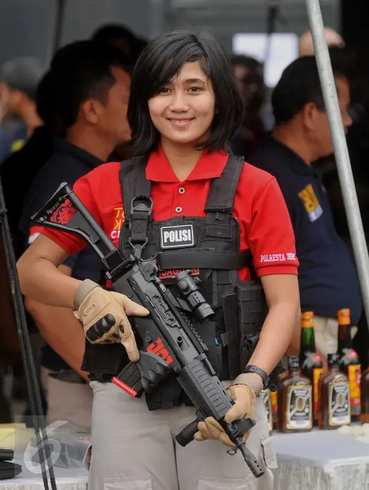 Bripda Suci Amelia, Tim Jaguar Polresta Depok, ketika rilis hasil pengungkapan Operasi Pekat di Polda Metro Jaya, Jumat (3/6). Pose polwan cantik yang sedang menenteng senjata api laras panjang mencuri perhatian pewarta foto. (Liputan6.com/Gempur M Surya)