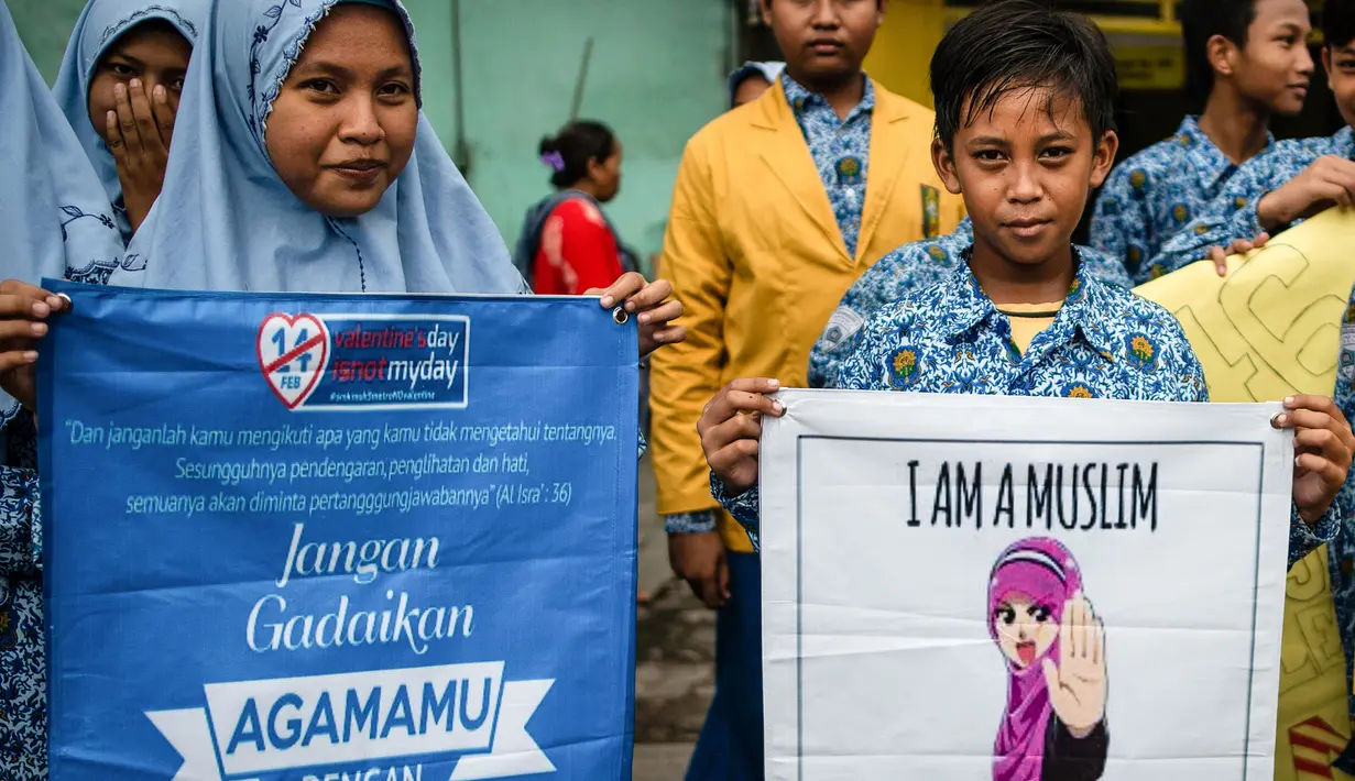 Dua orang pelajar menunjukkan spanduk saat menggelar demonstrasi menolak perayaan Hari Valentine di Surabaya, Jawa Timur, Kamis (14/2). Pelajar menilai Valentine sebagai pengaruh budaya asing. (Juni Kriswanto/AFP)