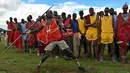 Seorang pria Maasai Moran melemparkan tongkat selama kompetisi Olimpiade Maasai 2018 di Kimana, Kenya (15/12). Olimpiade Maasai  sudah diadakan setiap dua tahun sejak 2012. (AFP Photo/Yasuyoshi Chiba)