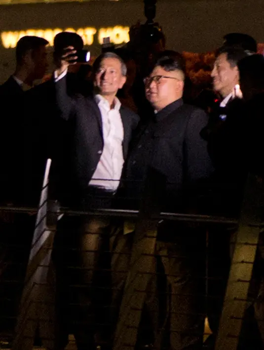 Menteri Luar Negeri Singapura, Vivian Balakrishnan berswafoto dengan pemimpin Korea Utara, Kim Jong-un di Marina Bay, Senin (11/6). Kim mengunjungi sejumlah tempat wisata di Singapura sebelum pertemuannya dengan Donald Trump. (AP Photo/Gemunu Amarasinghe)