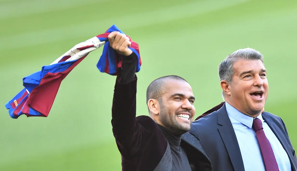 Bek baru Barcelona Dani Alves (kanan) dan presiden FC Barcelona Joan Laporta menyapa fans saat menghadiri upacara presentasi di stadion Camp Nou di Barcelona (17/11/2021). Dani Alves akan mengenakan nomor punggung 8 yang pernah di pakai Andreas Iniesta. (AFP/Pau Barrena)
