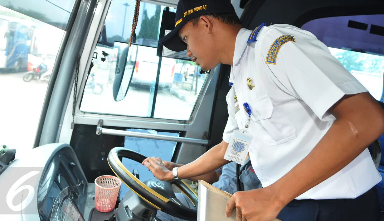 Petugas Dirjen Perhubungan melakukan pemeriksaan instrumen kemudi pada bus yang akan digunakan sebagai angkutan mudik lebaran 2015 di Terminal Pulogadung, Jakarta, Jumat (10/7). (Liputan6.com/Herman Zakharia)