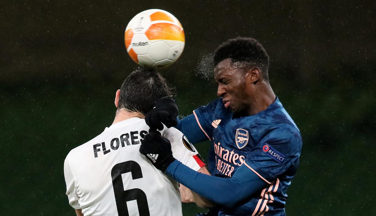 Striker Arsenal, Eddie Nketiah, berebut bola atas dengan gelandang Dundalk, Jordan Flores, pada laga lanjutan Liga Europa 2020/2021 di Aviva Stadium, Jumat (11/12/2020) dini hari WIB. Arsenal menang 4-2 atas Dundalk. (AFP/Paul Faith)