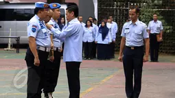 Sipir LP Kelas IIA Banceuy Bandung, yang menjadi tersangka peredaran narkoba di lapas, Dedi Romadi (tengah) mengenakan baju sipil usai melepaskan seragamnya pada upacara pemecatan di Lapangan Kemenkumham, Jakarta, Senin (1/6). (Liputan6.com/Johan Tallo)