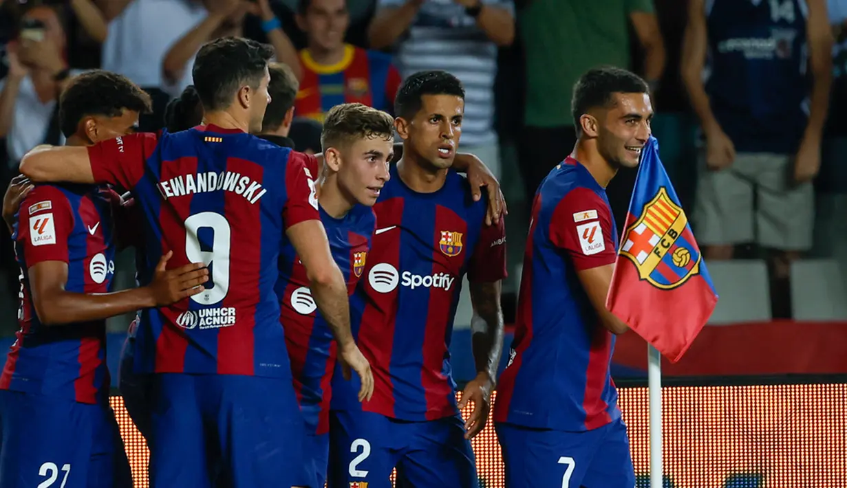 Para pemain Barcelona merayakan setelah pemain Sevilla Sergio Ramos mencetak gol bunuh diri melewati kipernya pada pertandingan sepak bola La Liga Spanyol di Olympic Stadium of Montjuic, Barcelona, Spanyol, Jumat (29/9/2023). Barcelona menang 1-0. (AP Photo/Joan Monfort)