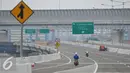 Pekerja melintas di jalan tol akses pelabuhan Tanjung Priok, Jakarta (27/5). Saat ini pekerjaan masih menyisakan pembangunan Seksi E2 dengan rute Cilincing-Jampea sepanjang 2,74 km. (Liputan6.com/Gempur M Surya)