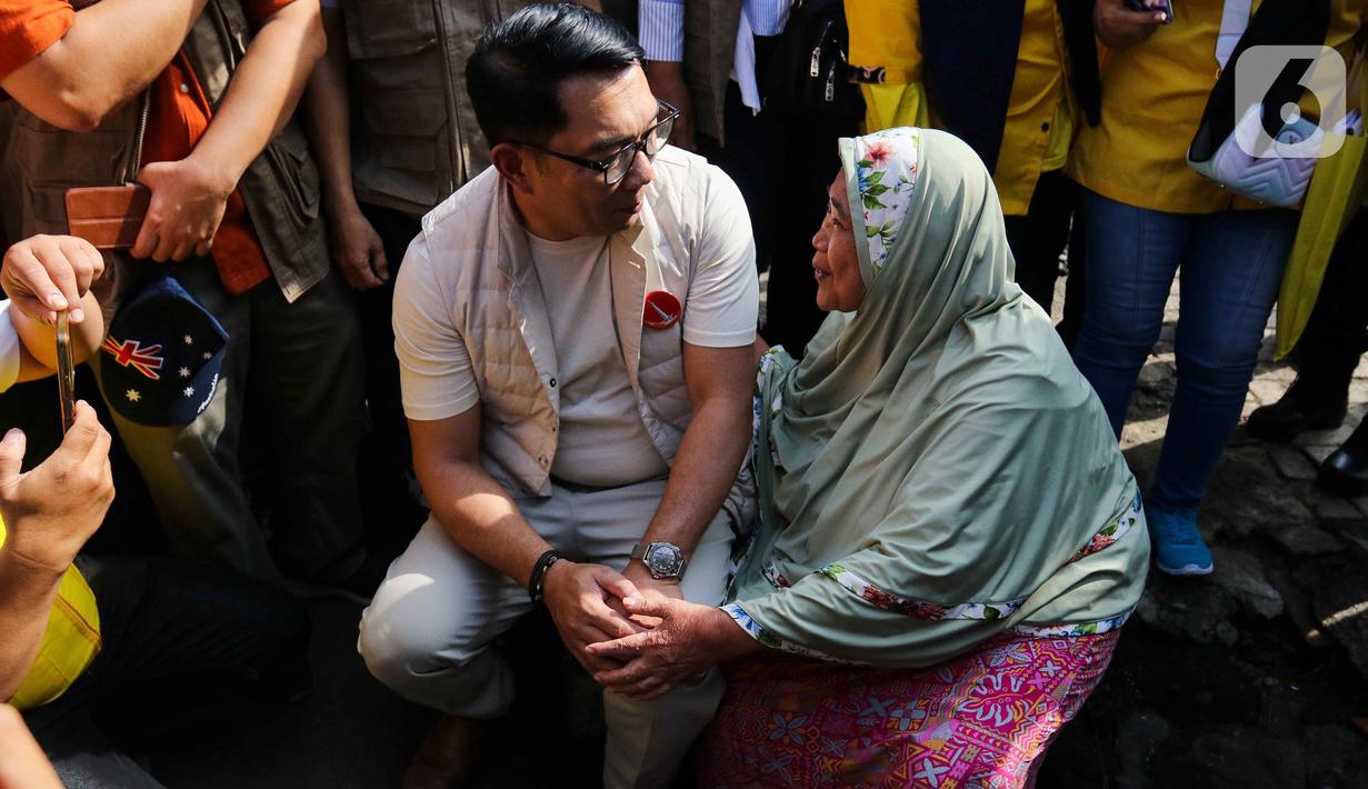 Calon gubernur DKI Jakarta nomor urut 1 Ridwan Kamil (kir) berbincang dengan salah satu warga di kawasan Pancoran, Jakarta Selatan, Kamis (26/9/2024). (Liputan6.com/Herman Zakharia)