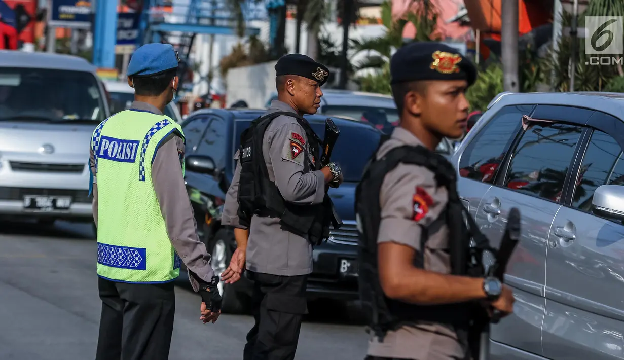 Personel Brimob bersenjata laras panjang ikut mengatur lalu lintas di kawasan jalur arus balik Pantura, Tegal, Jawa Tengah, Jumat (30/6). (Liputan6.com/Faizal Fanani)