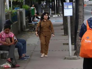 Seorang wanita berjalan di atas trotoar kawasan MH Thamrin, Jakarta, Selasa (6/3). Pemerintah Provinsi (Pemprov) DKI Jakarta mulai merencanakan penataan jalan dan trotoar di sepanjang Jalan Sudirman dan Jalan MH Thamrin. (Liputan6.com/Immanuel Antonius)