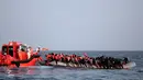 Para imigran berada di perahu karet saat diselamatkan di laut Mediterrania, (20/10). Jumlah imigran yang melewati Laut Mediterania pada tahun ini menurun dibanding tahun lalu. (Yara Nardi/Italian Red Cross press office/Handout via REUTERS)