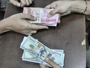Seorang warga menjual uang dolar Amerika Serikat di salah satu gerai money changer di Jakarta, Senin (4/7/2022). Rupiah kembali melemah melawan dolar Amerika Serikat (AS) pada perdagangan mendekati lagi Rp15.000 per USD 1 dan menjadi salah satu yang terburuk. (merdeka.com/Iqbal S Nugroho)