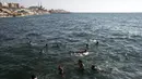Warga berenang saat menikmati musim panas yang cerah di pantai Kota Gaza, Palestina, Jumat (3/7/2020). (AP Photo/Khalil Hamra)