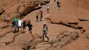 Wisatawan mendaki Uluru yang juga dikenal sebagai Batu Ayers di Taman Nasional Uluru-Kata Tjuta, utara Australia, Jumat (25/10/2019). Pendakian di Batu Ayers tersebut akan dilarang pada Oktober ini, seiring dengan keinginan Anagu, suku asli Aborigin yang mendiami kawasan tersebut. (SAEED KHAN / AFP)