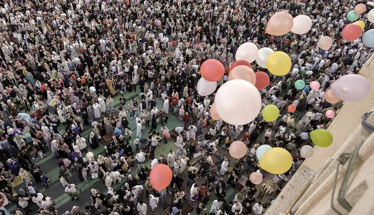 Balon dibagikan secara gratis setelah salat Idul Fitri, menandai berakhirnya bulan suci Ramadhan di luar masjid al-Seddik di Kairo, Mesir, Jumat, 21 April 2023. (AP Photo/Amr Nabil)