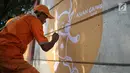 Petugas PPSU membuat mural bertema Asian Games di kawasan Cawang, Jakarta, Selasa (17/7). Mural tersebut dibuat untuk sosialisasi sekaligus bentuk dukungan terhadap perhelatan Asian Games pada Agustus 2018 mendatang. (Liputan6.com/Faizal Fanani)