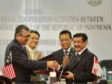 Jaksa Agung RI Basrief Arief (kanan) bertukar dokumen dengan Jaksa Agung Malaysia Tan Sri Abdul Gani Patail (kiri) usai penandatangan kerjasama bidang hukum, Jakarta, Senin (2/4). Perjanjian tersebut berisi kerjasama penegakan hukum, pengurangan kejahatan lintas negara terutama kasus korupsi dan terorisme. (Antara)