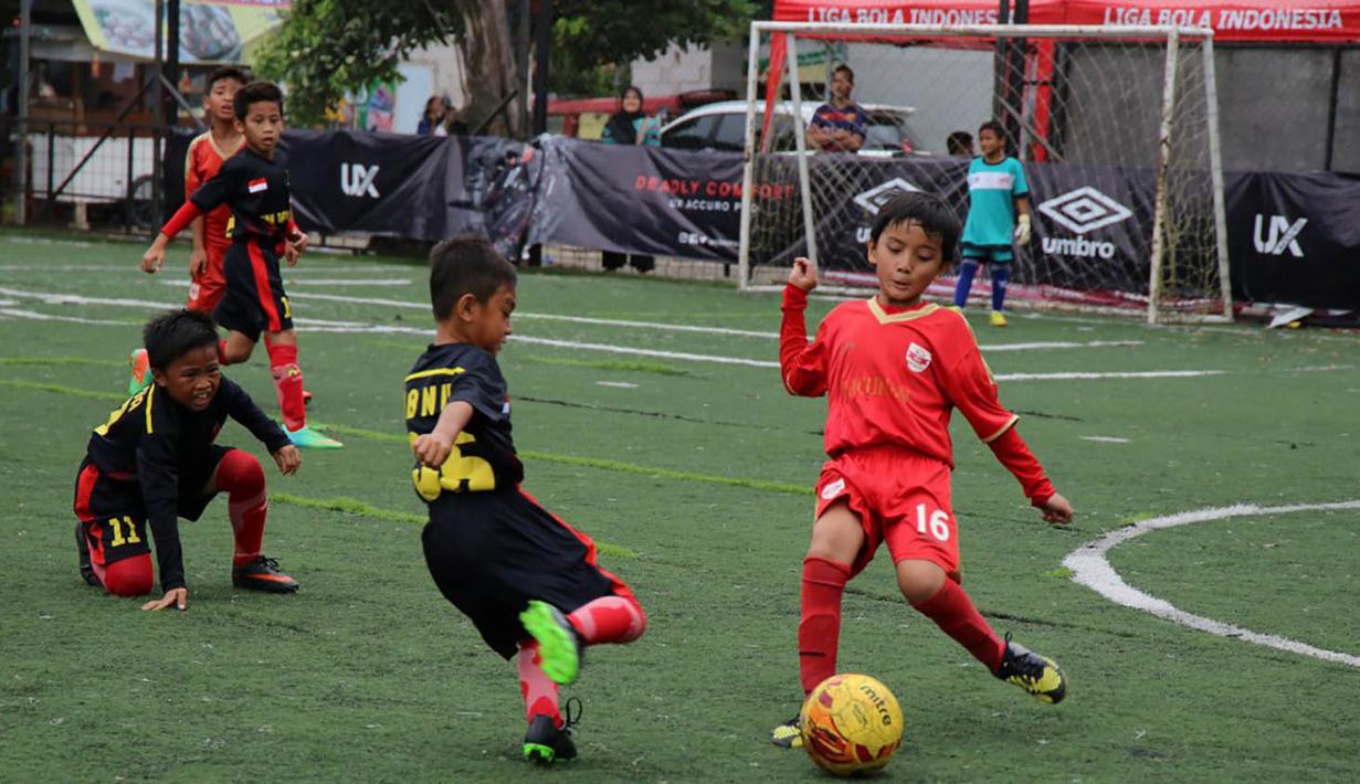 Seorang anak berusaha mengecoh lawannya saat laga Liga Bola Indonesia. Sementara itu klub Ragunan berada pada posisi kedua klasemen U-9. (Bola.com/Vitalis Yogi Trisna)