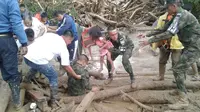 Tentara Nasional Kolombia saat mengevakuasi warga dari musibah banjir bandang dan longsor (Colombian Army/AP)