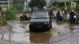 Kendaraan menghindari kubangan pada jalan yang rusak di Jalan Pertamina, Kemiri Muka, Depok, Jawa Barat, Selasa (5/3). Kondisi tersebut mengganggu aktivitas warga serta pengguna jalan. (Liputan6.com/Immanuel Antonius)