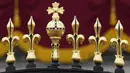 Ornamen emas terlihat di atas gerbang Istana Buckingham sebelum upacara penobatan Raja Charles III  di London, Sabtu (6/5/2023). (AP Photo/Frank Augstein)