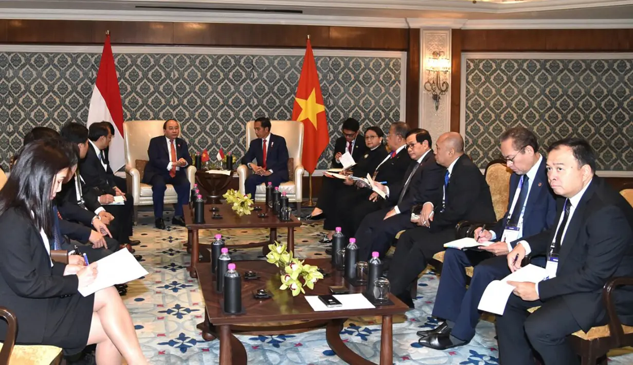 Presiden Jokowi berbincang dengan PM Vietnam, Nguyen Xuan Phuc dalam pertemuan bilateral disela KTT ASEAN-India di New Delhi, Jumat (26/1). Pertemuan membahas peningkatan hubungan kerja sama ekonomi dan maritim. (Liputan6.com/Pool/Biro Pers Setpres)