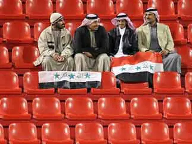Empat fans Irak di tengah kosongnya Ahmed bin Ali Stadium, Al Rayyan, Qatar, ketika digelar penyisihan Grup D Piala Asia 2011 antara Irak vs Korut, 19 Januari 2011. AFP PHOTO / KARIM JAAFAR 
