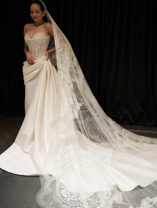 Gaun ini dipadukan dengan veil bersulam halus sepanjang empat meter [@monicaivena]
