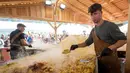 Koki memasak rosti dalam upaya memecahkan rekor dunia saat acara yang menandai peringatan 125 tahun Serikat Petani Swiss (SBV) di Bern, Swiss pada 19 September 2022. Rosti atau roschti adalah makanan khas Swiss berbahan dasar kentang yang dihaluskan dan digoreng menggunakan sedikit minyak. (Fabrice COFFRINI / AFP)