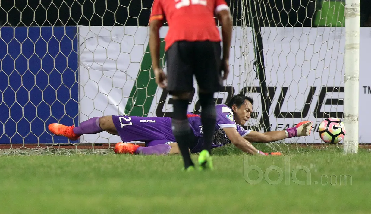 Kiper Bali United, I Made Wardana menepis tendangan penalti pemain Persija Jakarta, Luiz Junior pada laga Liga 1 2017 di Stadion Patriot, Bekasi, Minggu (21/5/2017). (Bola.com/NIcklas Hanoatubun)