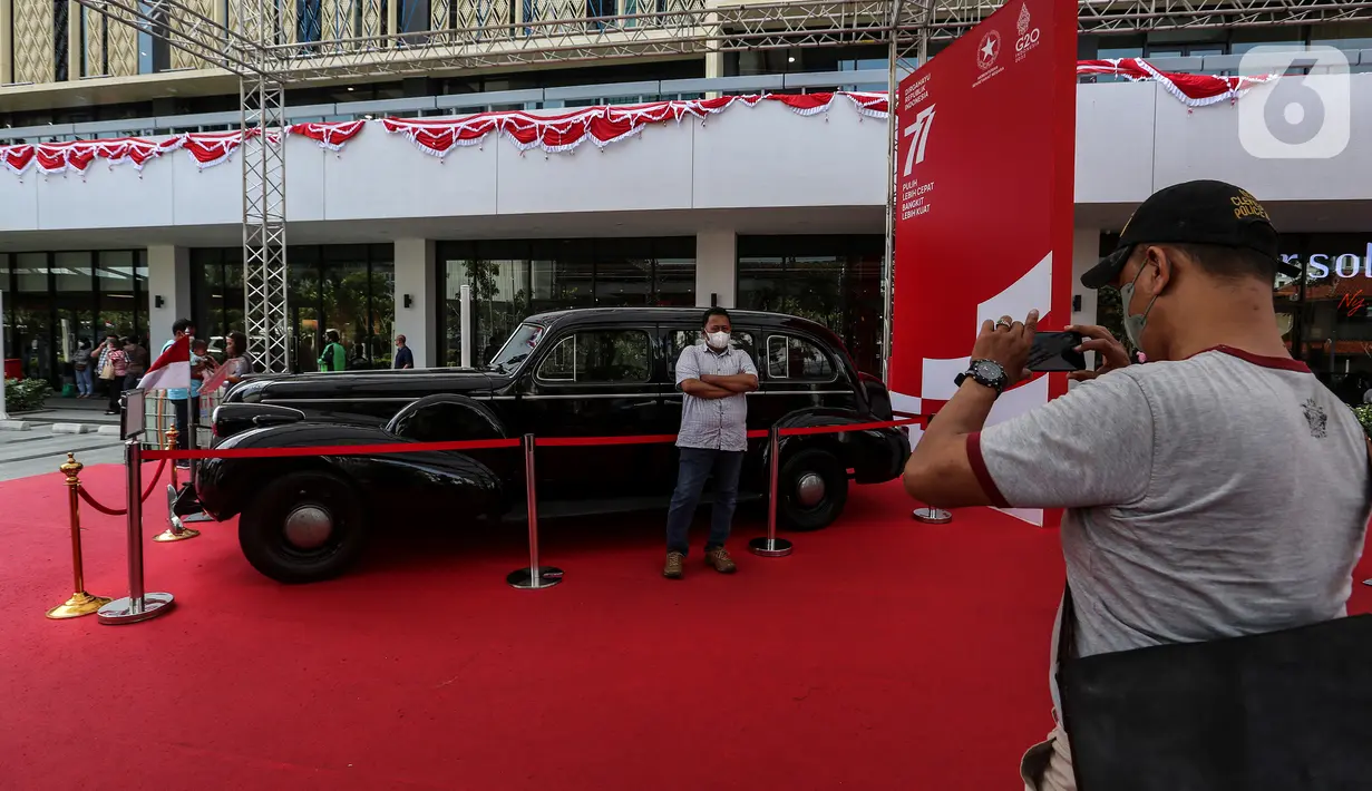 Pengunjung berfoto dengan salah satu mobil kepresidenan yang dipamerkan di Gedung Sarinah, Jakarta Pusat, Kamis (18/8/2022). Pameran dalam rangka Hari Ulang Tahun ke-77 Kemerdekaan Republik Indonesia ini digelar hingga 22 Agustus mendatang dan memamerkan mobil kepresidenan dari Era Presiden Soekarno hingga Presiden Joko Widodo. (Liputan6.com/Johan Tallo)