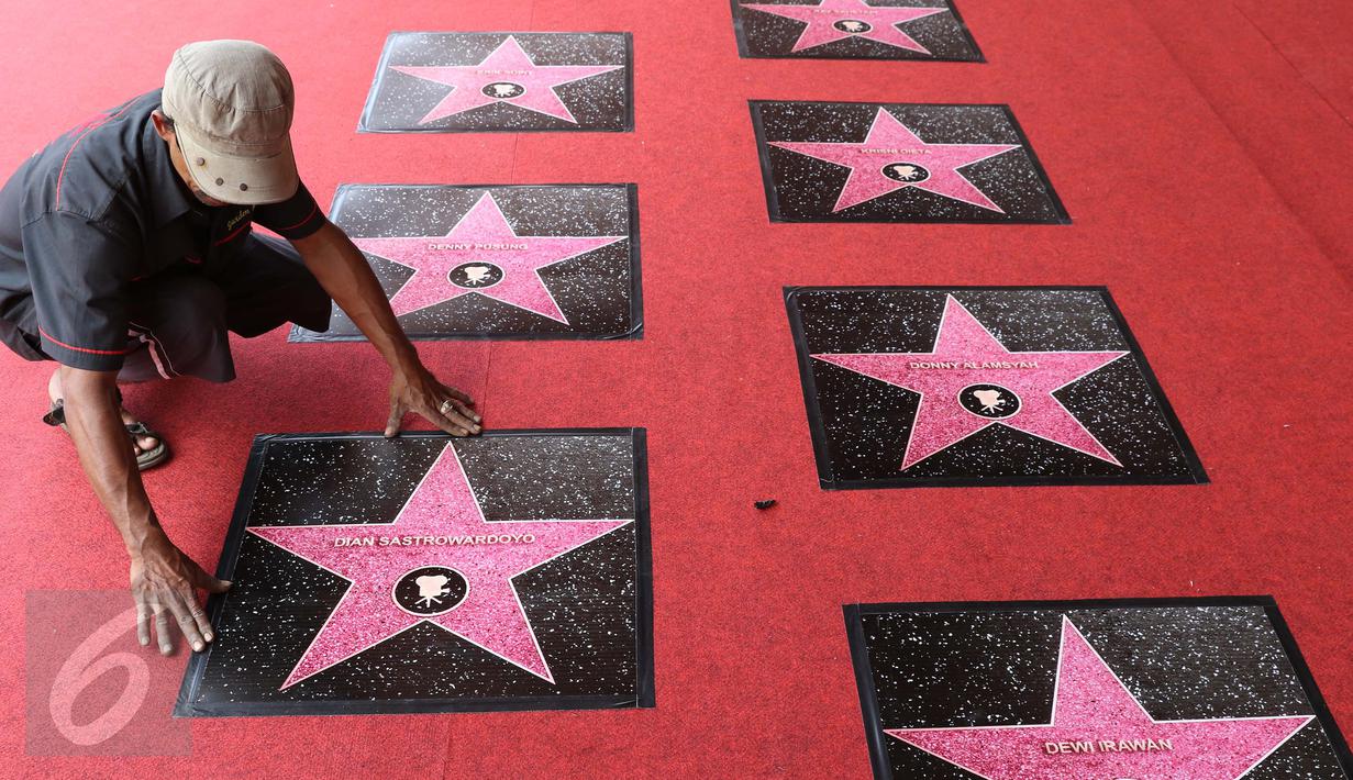Petugas saat memasang prasasti berbentuk bintang (walk of fame) jelang perhelatan malam puncak Festival Film Bandung (FFB) 2015 di Monumen Perjuangan Rakyat, Bandung, Sabtu (12/9/2015). (Liputan6.com/Herman Zakharia)