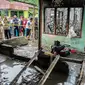 Warga berkerumun di sekitar lokasi kebakaran pabrik korek gas di Binjai, Langkat, Sumatera Utara, (21/6/2019). Korban tewas dalam kebakaran tersebut terdiri dari ibu rumah tangga dan anak-anak. (Ivan Damanik/AFP)