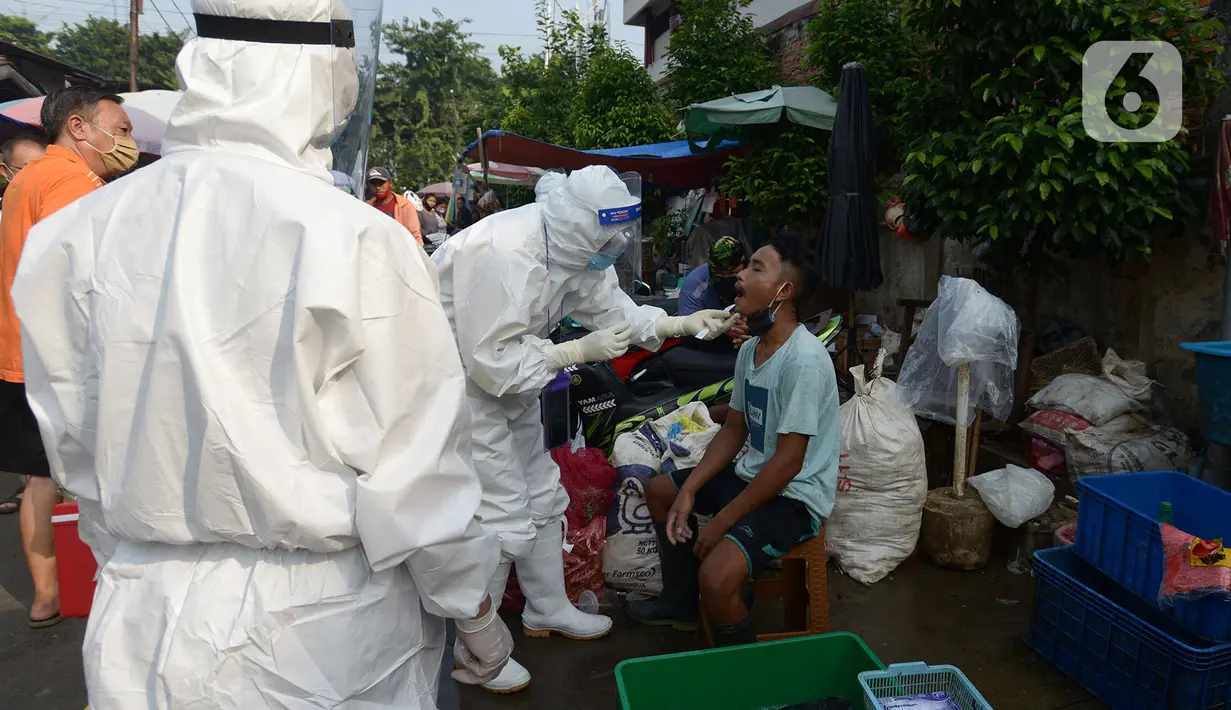 Petugas medis melakukan tes usap (swab test) ke pedagang Pasar Karang Anyar di Jakarta, Kamis (26/6/2020). Tes swab dengan metode PCR dilakukan secara masif setelah adanya pelonggaran PSBB, terutama di wilayah yang berpotensi tinggi menjadi tempat penularan Covid-19. (merdeka.com/Imam Buhori)