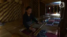 Warga suku Baduy menenun kain di Ciboleger, Lebak, Banten Jumat (15/10/2021). Harga kain tenun  dijual dengan kisaran harga mulai dari Rp 120 ribu hingga Rp. 750 ribu perpotong tergantung jenis dan motif. (merdeka.com/Imam Buhori)