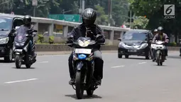 Warga mengoperasikan telepon seluler saat mengendarai sepeda motor di Jalan Gatot Subroto, Jakarta, Kamis (8/3). Menurut pihak kepolisian kecelakaan akibat penggunaan telepon genggam saat mengemudi kerap terjadi. (Liputan6.com/Arya Manggala)