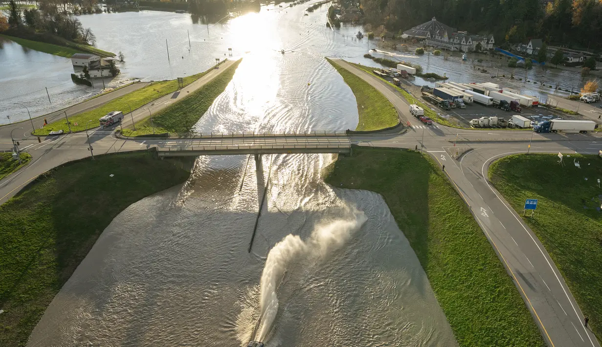 Sebuah perahu melewati jalan layang saat melaju di sepanjang jalan raya 1 yang banjir di Abbotsford, British Columbia, Kanada, Selasa (16/11/2021). Hujan deras selama dua hari di provinsi British Columbia menyebabkan banjir besar.  (Jonathan Hayward/The Canadian Press via AP)