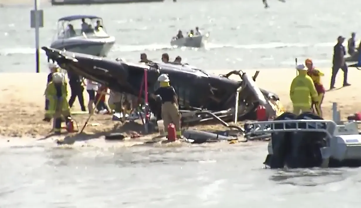 Gambar yang diambil dari video ini menunjukkan pulau pasir dengan helikopter yang jatuh, korban dan layanan darurat di Gold Coast, Australia Senin, 2 Januari 2023. Dua helikopter bertabrakan di hotspot wisata Australia Senin sore. (CH9 via AP)