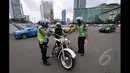Mulai hari Minggu (18/1/2015), petugas kepolisian memberikan sanksi berupa denda senilai Rp 500 ribu bagi pemotor yang nekat melintasi Jalan MH Thamrin-Medan Merdeka Barat, Jakarta. (Liputan6.com/Miftahul Hayat)