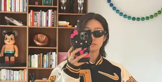 Peggy Gou kenakan varsity jaket dengan nuansa hitam, putih, dan kuning. Jaket Nike tersebut tampak statement dengan tempelan emblem yang menyempurnakan gaya. [Foto: Instagram/ Peggy Gou]